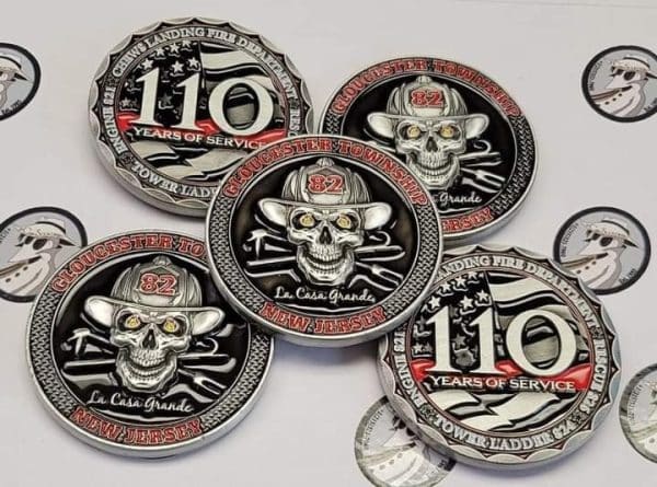 A collection of custom-made Challenge Coins featuring skulls and various emblems, celebrating 110 years of service.